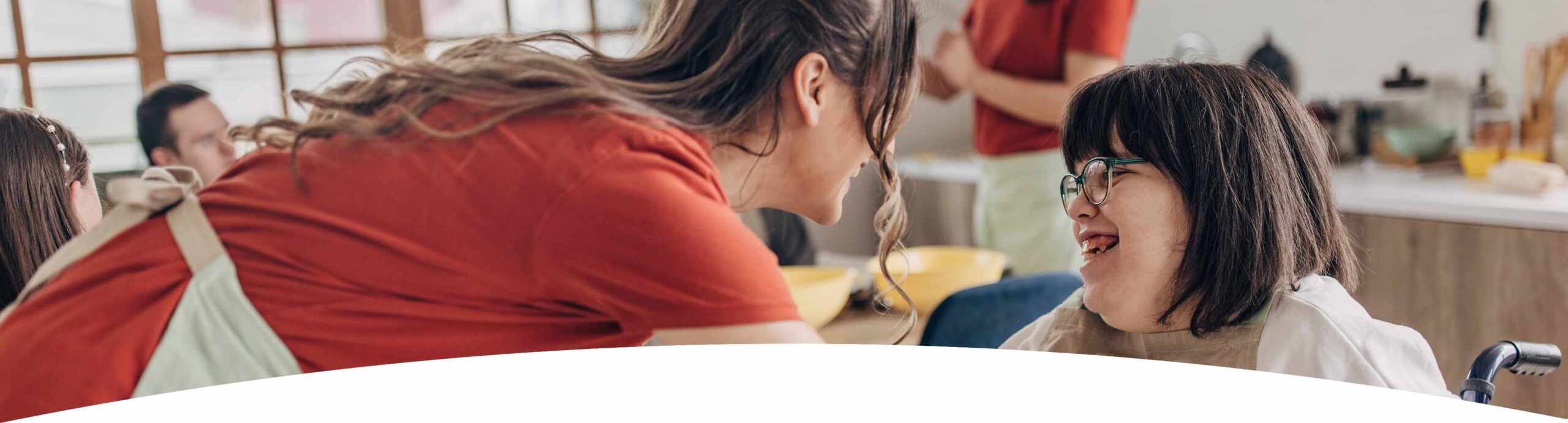 header_dashaus Behindertes Mädchen und Betreuerin unterhalten sich und lachen