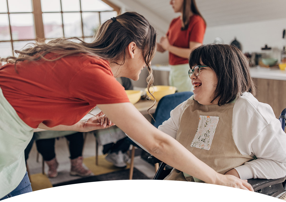 header_dashaus_mob Behindertes Mädchen und Betreuerin unterhalten sich und lachen